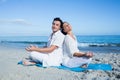 Happy couple doing yoga beside the water Royalty Free Stock Photo