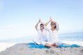 Happy couple doing yoga beside the water Royalty Free Stock Photo