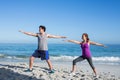 Happy couple doing yoga beside the water Royalty Free Stock Photo