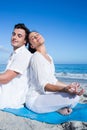 Happy couple doing yoga beside the water Royalty Free Stock Photo