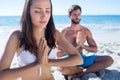 Happy couple doing yoga beside the water Royalty Free Stock Photo