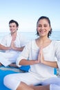 Happy couple doing yoga beside the water Royalty Free Stock Photo