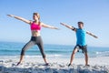 Happy couple doing yoga beside the water Royalty Free Stock Photo