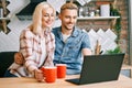 Happy couple drink coffee and using laptop relax together at their kitchen Royalty Free Stock Photo