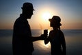 A Happy couple drinking cocktail by the sea at sunset on travel silhouette in nature Royalty Free Stock Photo