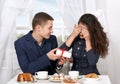 Happy couple drinking coffee and having fun, give gifts near window with a sky view - love and holiday concept Royalty Free Stock Photo