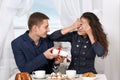 Happy couple drinking coffee and having fun, give gifts near window with a sky view - love and holiday concept Royalty Free Stock Photo