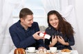 Happy couple drinking coffee and having fun, man give very funny gifts - love and holiday concept Royalty Free Stock Photo