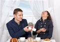 Happy couple drinking coffee and having fun, man give very funny gifts - love and holiday concept Royalty Free Stock Photo