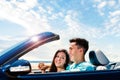 Happy couple driving convertible along seaside. Royalty Free Stock Photo