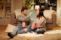 Happy couple eating popcorn at home