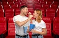 Happy couple eating popcorn at movie theatre Royalty Free Stock Photo