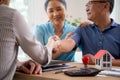 Happy couple elderly handshake with mortgage officer with agreement approve of buying home with loan. Royalty Free Stock Photo