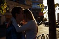 Happy couple is embracing in the street, the suns rays shine on their faces, dark background. date in the city Royalty Free Stock Photo