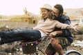 Happy couple enjoy outdoor leisure activity together carrying and using a bike and laughing a lot. Love and friendship with mature