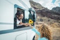 Happy couple enjoy travel with camper van. Man give a flower to her girlfriend outside the vehicle. Road trip destination and off Royalty Free Stock Photo