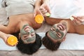 Happy couple enjoying facial treatment procedure in spa salon
