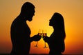 Happy couple enjoying a glass of wine or champagne, silhouette of couple in love drinking wine from wineglasses during romantic di Royalty Free Stock Photo