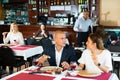 Happy couple enjoying pizza with wine in restaurant Royalty Free Stock Photo