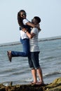 The young couple hugging against the sea and sky. Man lifted up woman holding each other and laughing Royalty Free Stock Photo