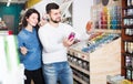 happy couple examining various paints in paint store Royalty Free Stock Photo