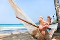 Happy couple family in hammock on tropical paradise beach, island holidays