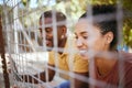 Happy couple, fence and smile at animal shelter, pet centre or zoo looking for a cute companion to adopt. Black man and Royalty Free Stock Photo