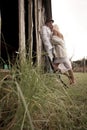 Happy couple flirting playfully outdoors against barn wall Royalty Free Stock Photo