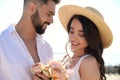 Happy couple with flowers at beach near sea. Honeymoon trip