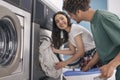 Happy Couple Folding Laundry Together At Laundromat Washing Machine Indoor