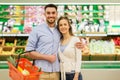 Happy couple with food basket at grocery store Royalty Free Stock Photo