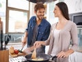 Happy couple, food and cooking together in a pan in the kitchen with healthy organic ingredients for dinner at home. Man Royalty Free Stock Photo