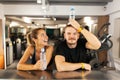 Happy couple fooling around with water bottles while resting in a fitness club