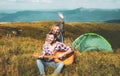 Happy couple friends camping, and playing guitar together in summer at nature forest. Couple in love on camp. Royalty Free Stock Photo