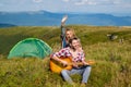 Happy couple friends camping, and playing guitar together in summer at nature forest. Couple in love on camp. Royalty Free Stock Photo