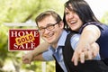 Happy Couple in Front of Sold Real Estate Sign Royalty Free Stock Photo