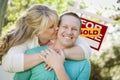 Happy Couple In Front Sold Real Estate Sign Royalty Free Stock Photo