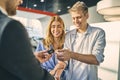 Happy couple getting a car key from stylish sale manager Royalty Free Stock Photo