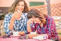 Happy couple of girlfriends drinking cappuccino and having fun