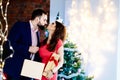 Happy couple giving Christmas presents and kissing