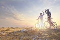 Happy couple goes on a mountain asphalt road in the woods on bikes with helmets giving each other a high five Royalty Free Stock Photo