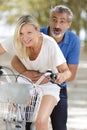 Happy couple going for bike ride in city Royalty Free Stock Photo