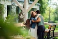 Happy couple greeting outdoors on terrace restaurant, hugging. Royalty Free Stock Photo