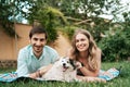 Beautiful couple with a dog on the grass