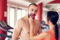 Happy couple in gym feeding each other with apple Royalty Free Stock Photo