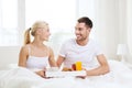 Happy couple having breakfast in bed at home Royalty Free Stock Photo