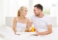 Happy couple having breakfast in bed at home Royalty Free Stock Photo