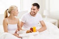 Happy couple having breakfast in bed at home Royalty Free Stock Photo