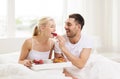 Happy couple having breakfast in bed at home Royalty Free Stock Photo