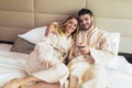 Happy couple having breakfast in luxury hotel room, watching TV Royalty Free Stock Photo